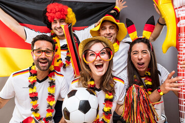 Gruppe gl&uuml;cklicher Fu&szlig;ballfans aus Deutschland feiern gemeinsam einen Meisterschaft Sieg.