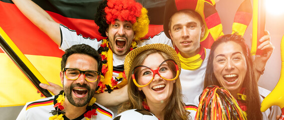 Fototapeta premium Gruppe glücklicher Fußballfans aus Deutschland feiern gemeinsam einen Meisterschaft Sieg.