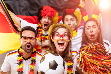 Gruppe glücklicher Fußballfans aus Deutschland feiern gemeinsam einen Meisterschaft Sieg. © karepa
