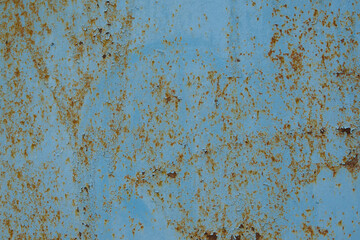 the texture of an old iron wall that was painted with blue paint. over time, the paint peeled off and the iron began to rust. from this beautiful stains went over the paint.