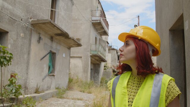 Giovane donna tecnico o ingegnere controlla la citt&agrave; distrutta dopo il terremoto