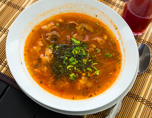 Rich mutton broth with rice, tomatoes and herbs - traditional Georgian soup Kharcho