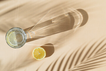 lemonade and palm tree shadow on beige background with shadows