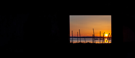 Vue d'un coucher de soleil sur un étang de la Camargue, réserve naturelle protégée depuis une...
