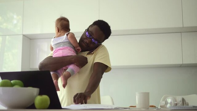 African Dad Is Holding Baby In Arms And Talking On Phone About Working From Home Spbd.