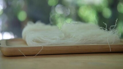 Raw of Thai glass noodles, drop on wood tray