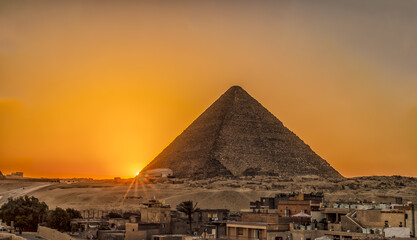 Obraz na płótnie Canvas The Sun Setting Behind the Left Corner of the Great Pyramid of Giza