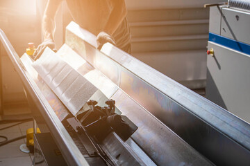 production of air ducts on industrial machines from galvanized steel, the foreground and background are blurred with a bokeh effect