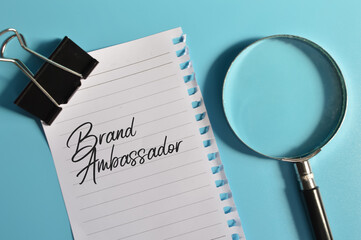 Top view of magnifying glass and white paper written with BRAND AMBASSADOR
