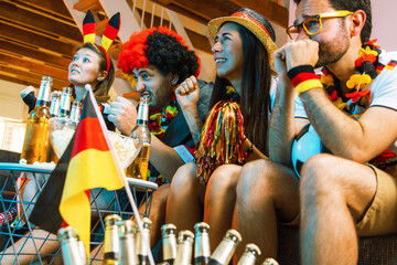 Gruppe glücklicher Fußballfans aus Deutschland feiern gemeinsam einen Meisterschaft Sieg. © karepa