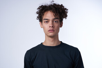 man in a black sweater on a light background curly hair portrait
