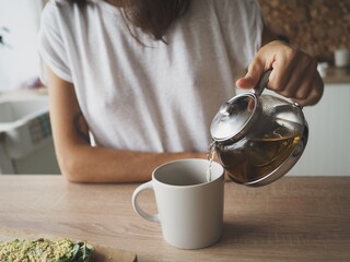 
young woman preparing breakfast, making tea, eating healthy food