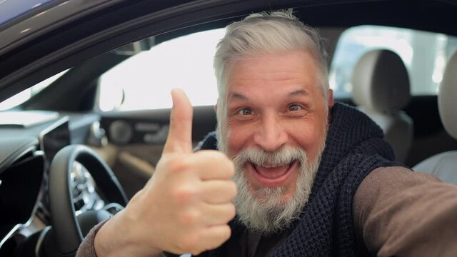 Buy car, portrait old happy man show thumbs up inside new vehicle, looking at camera Spbi. Aged