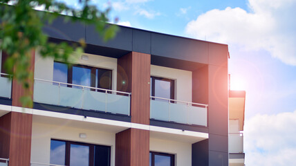 Modern apartment buildings on a sunny day with a blue sky. Facade of a modern apartment building. Glass surface with sunlight.