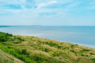 Spring and summer landscape. Green meadows with trees and a river in the background