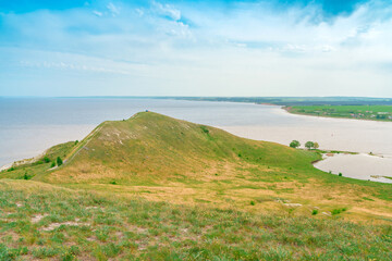 Spring and summer landscape. Green meadows with trees and a river in the background