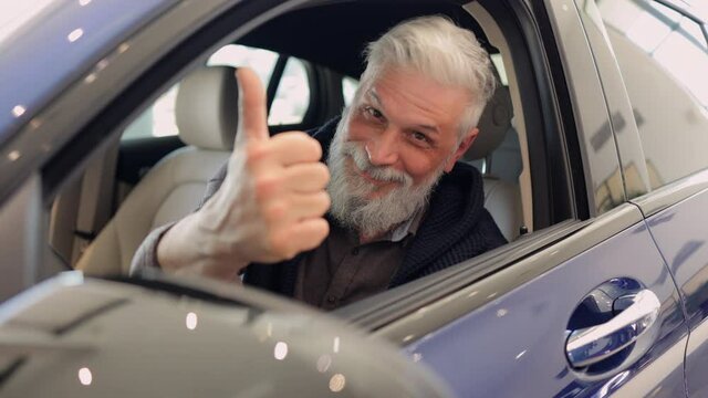 Senior driver with grey beard takes new car for test drive Spbi