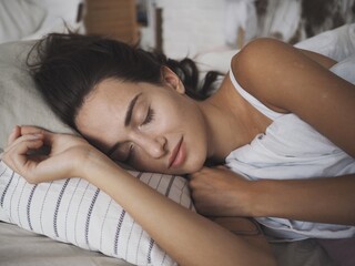 
young woman sleeping in her bed at home