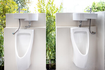 Urinals for men to urinate and hand washing point in the male toilet at park,white urinal with a...