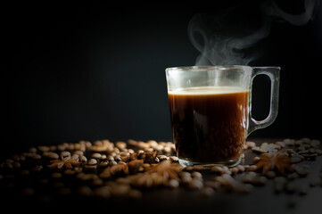 a cup of coffee on a black background with grains and badyan. High quality photo