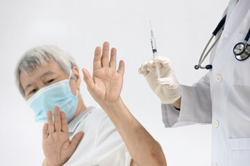 Doctor prepares to vaccinate,old senior refusing to receive a Coronavirus vaccine,uneasiness of...