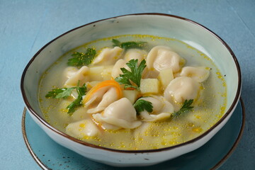 Soup with pelmeni (russian dumplings). Soup with meat dumplings, potatoes and other vegetables