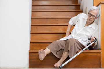 Senior woman sitting on the floor of the staircase with pain in hips and back,tripped or lose...