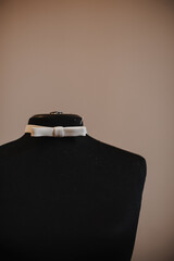 manikin for sewing clothes with a white belt and a needle