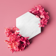 Marble  hexagon on pink background with flowers. Stylish background for presentation.