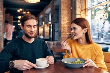 woman and man dining in restaurant salad meal food cup of coffee
