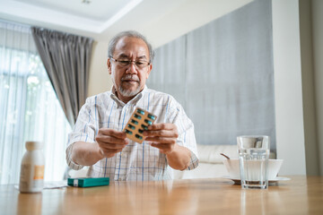 Asian old man read drug label, check instructions before or after meal