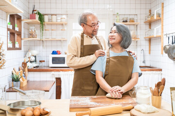 Loving Senior elderly couple stand in kitchen at house enjoy cook food