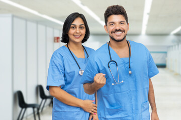 Happy latin american male and female nurses at vaccination station