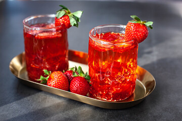 Red drink with ice and strawberry with leaves