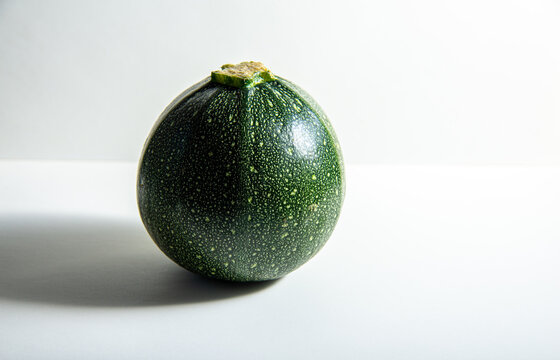 green round cougette or zucchini isolated on white background .