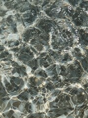 Clear blue water with waves sunlight shadow reflections. Summer vacation background