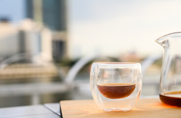 Drip freshly brewed coffee in a cup and glass pot on wooden tray. Hot brew coffee drink is good for health, Natural light. copy space.