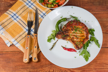 Grilled pork loin chop bone-in on dish, top view