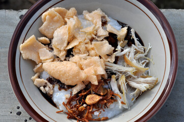 Chicken porridge in Indonesia complete with sliced chicken and crackers