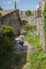 Fototapeta na wymiar Femme touriste descendant une ruelle du village fortifié de Soyans dans la Drôme provençale