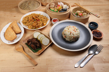 Dumplings dim sum bamboo steamer egg fried rice pulut lemang beef rendang stair fried tofu shrimp noodles chili oil dark soya sauce chpstick fork spoon on wooden table variety cuisine snack fast food