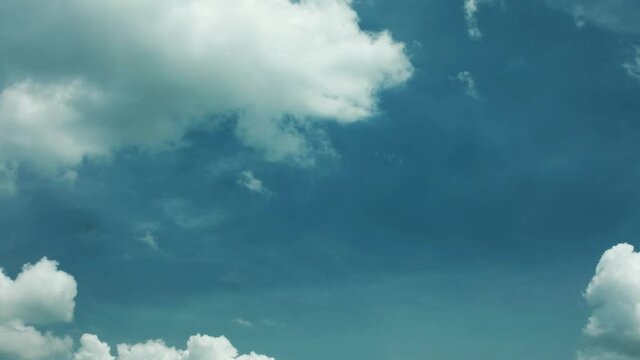 Timelapse of Fast Moving Cumulus Clouds Moving from Right to Left Across Blue Skies with a Thin Upper Layer of Moving Cirrus Clouds in Opposite Direction