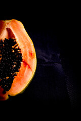 Half of an open papaya with the seeds