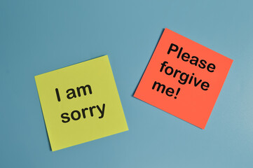 Paper notes written with I AM SORRY and PLEASE FORGIVE ME!
