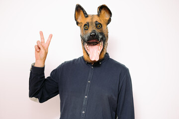 person with a dog mask making the victory sign