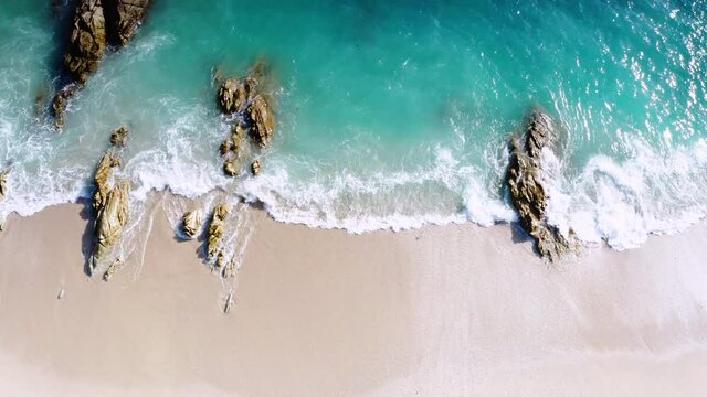 4K Aerial drone top down view bird eye view of sea blue waves break on rock and sand. Beautiful of sea water wave come to beach. Phuket Thailand tropical beach