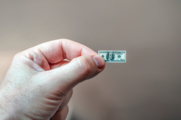 concept of dollar inflation. cash on hand. Hand holding miniature dollar note