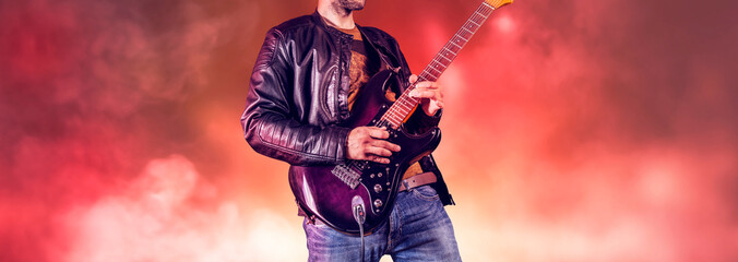 Rock guitarist plays solo on an electric guitar. Artist and musician performs like rockstar. Guitar...