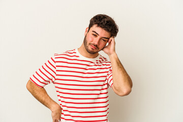 Young caucasian man isolated on white background tired and very sleepy keeping hand on head.
