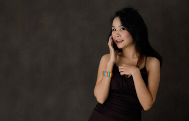 Happy laughing young Asian woman in studio